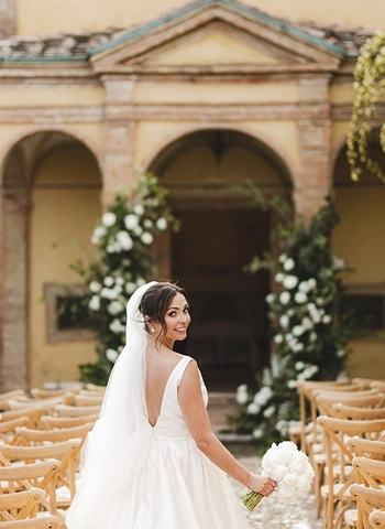 Bride turn around and looks back along ceremony aisle
