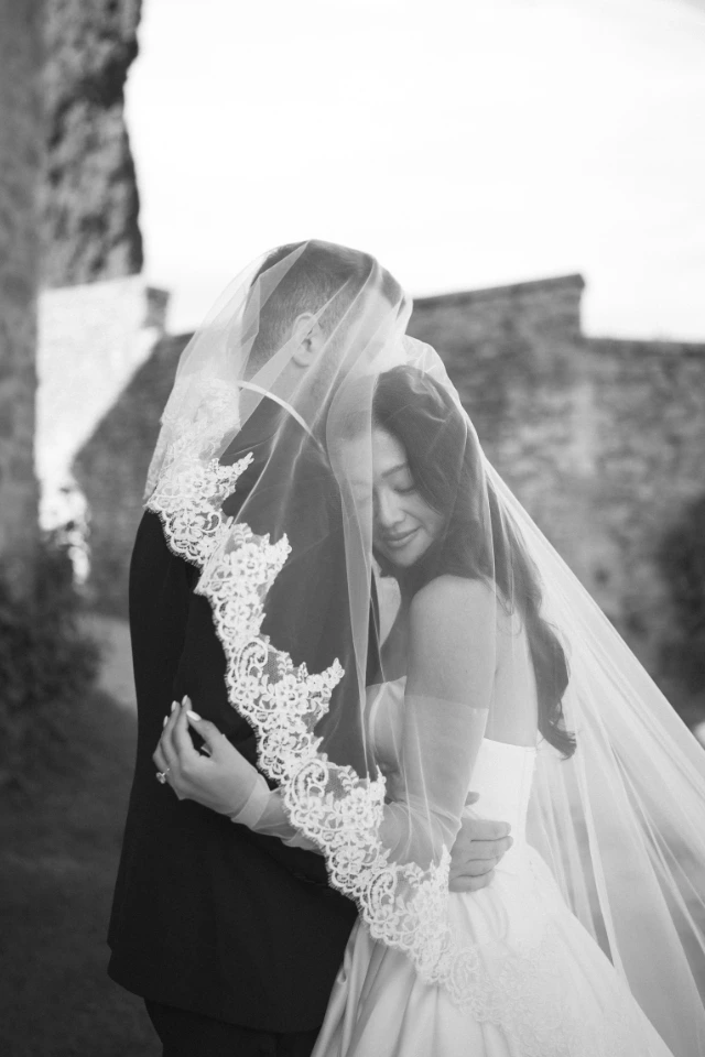 Bride and groom hug each other under the veil after the first look, photo by Andrea Corsi, planning Floé Weddings