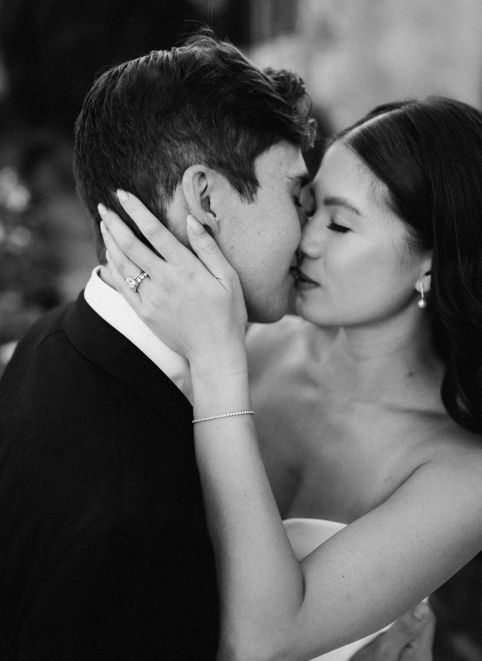 Bride and groom kiss passionately in timeless black and white couple potrtrait