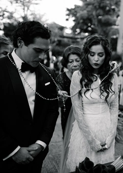 Brdie and groom performing the el lazo hispanic ritual during wedding ceremony