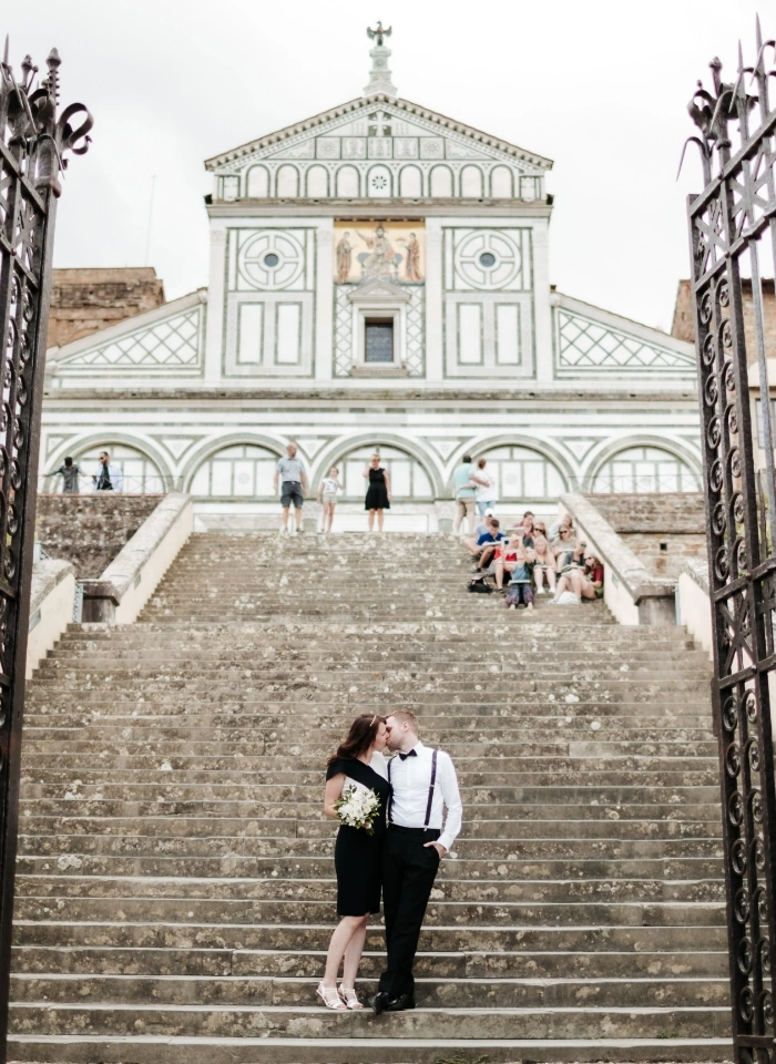 Bride and groom kissing on steps of San Miniato al Monte in Tuscany after eloping
