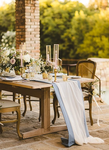 Dinner centerpiece on rustic country table for intimate wedding reception in Tuscany