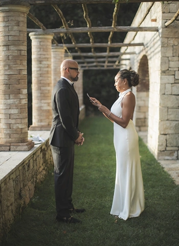 Bride and groom exchanging vows during renewal of vows ceremony under Borgo Pignano's pergola