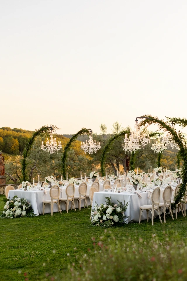 Imperial tables with arches and chandeliers surrounded by the Tuscan countryside.