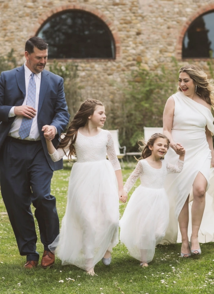 Bride and groom walking with two daughters after wedding anniversary renewal of vows ceremony