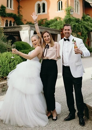 Wedding planner Sara barni happily cheering with satisfied bride and groom