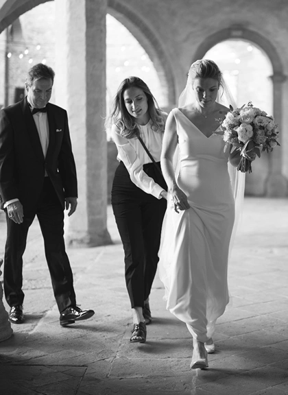 Sara Barni helping bride walk by holding her dress's train