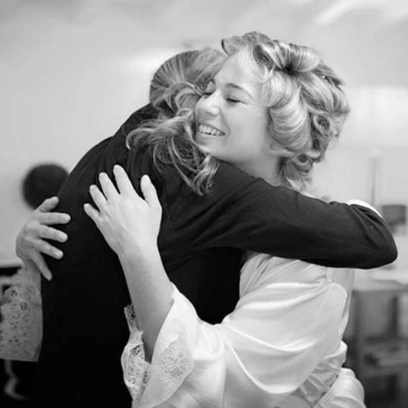 Wedding planner Sara Barni hugging happy bride
