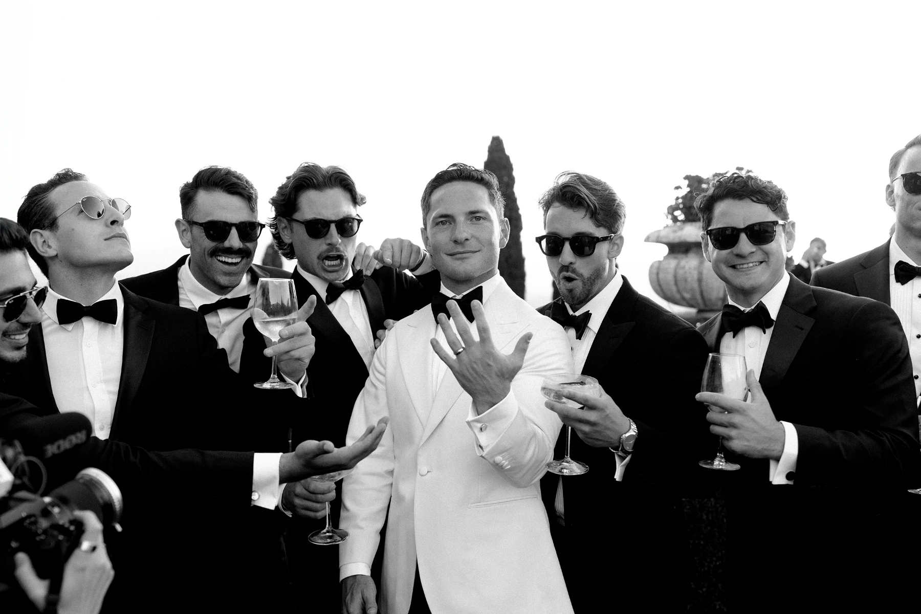 Stylish groom proudly shows off his wedding band in front of groomsmen at La Foce