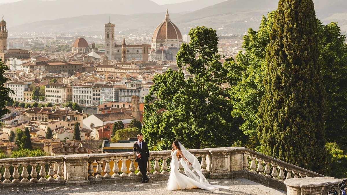 Couple shoot of newlyweds with bride walking over towards the groom with a panoramic view of Florence