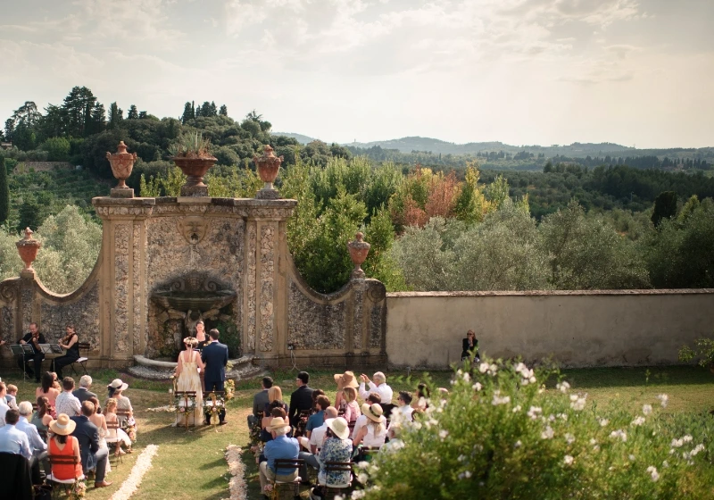 Outdoor wedding ceremony in the back garden of Villa Medicea di Liliano in front of stone walls 