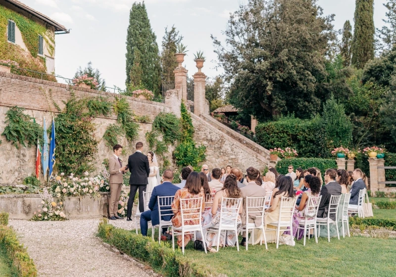 Outdoor civil wedding ceremony in Tuscany with Italian flags as backround
