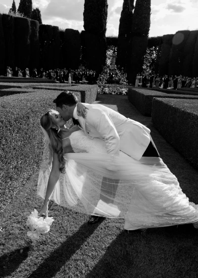 Black and white timeless picture of bride and groom kissing with dip after ceremony exit at La Foce