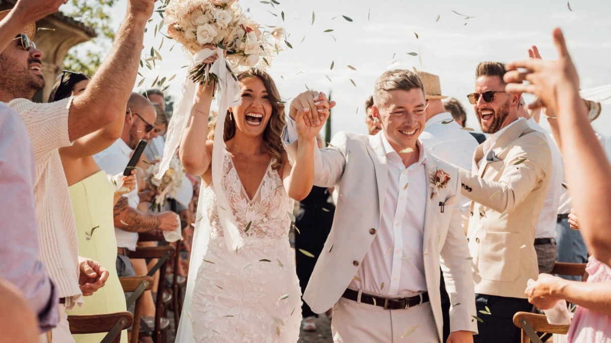 Newlyweds happily exit at the end of the wedding ceremony with petal toss