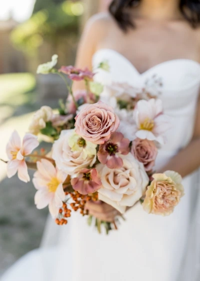Close up of pink bridal bouquet with roses, tulips and choco lisianthus