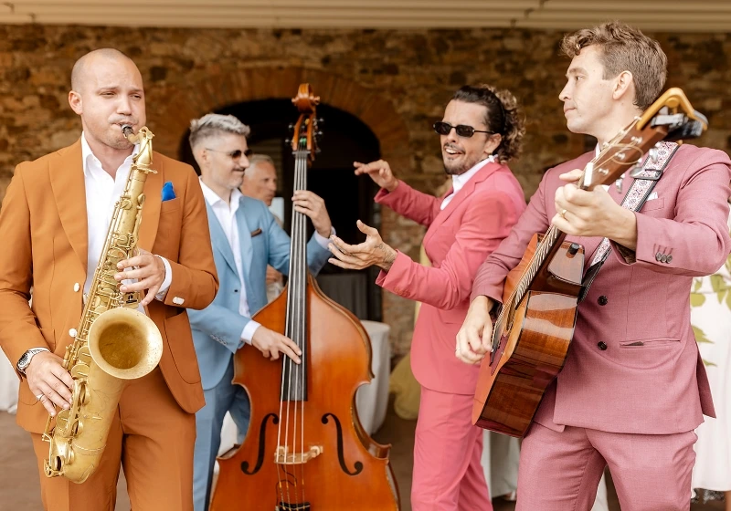 Roaming band plays music during wedding day in stylish and colorful suits