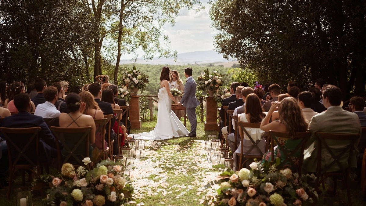 Outdoor symbolic wedding ceremony in Tuscany with pink, white and green florals
