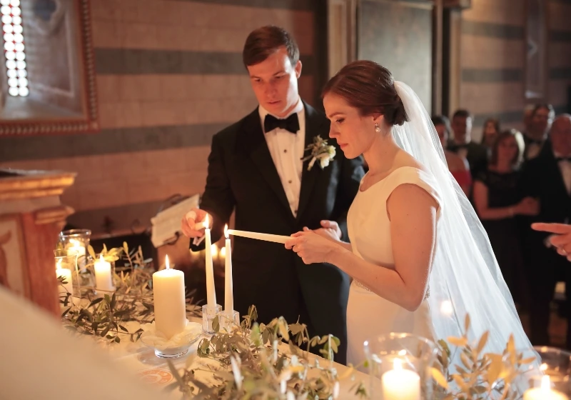 Bride and groom participate in unity candle ritual during symbolic wedding ceremony in Tuscany