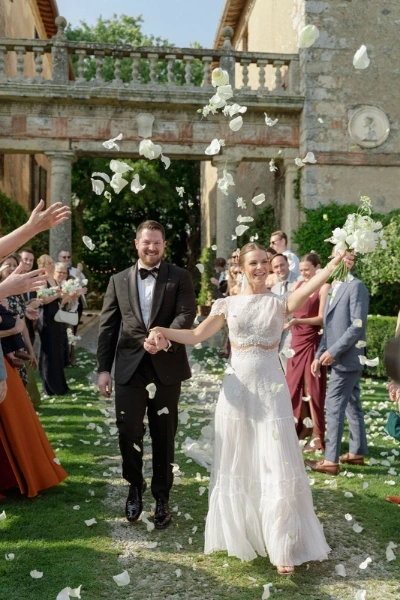 Bride and groom during the petal toss at their ceremony at Borgo Stomennano