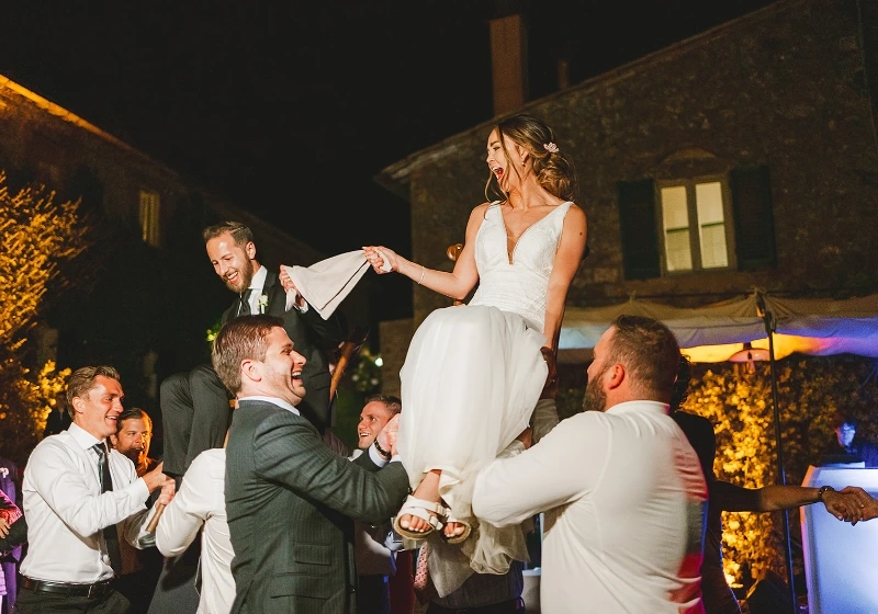 Photo of bride and groom having fun with their families and friends