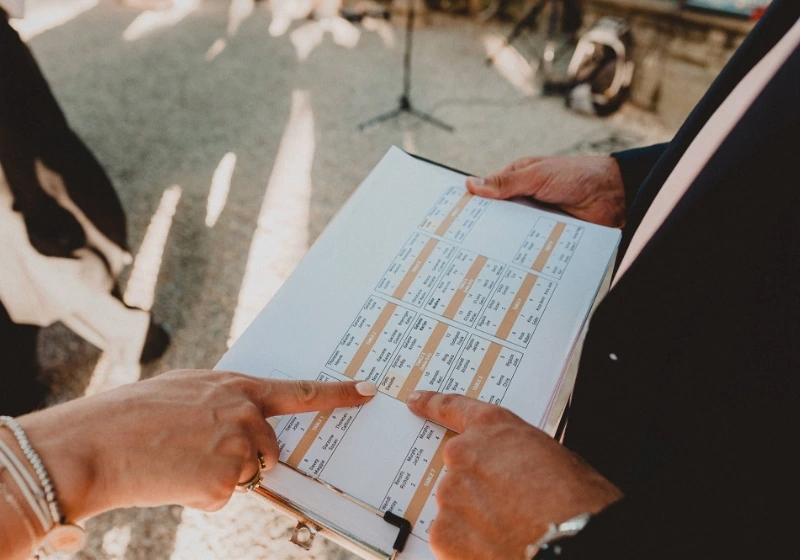 Photo of the hands of the bride and the groom with the tableplan