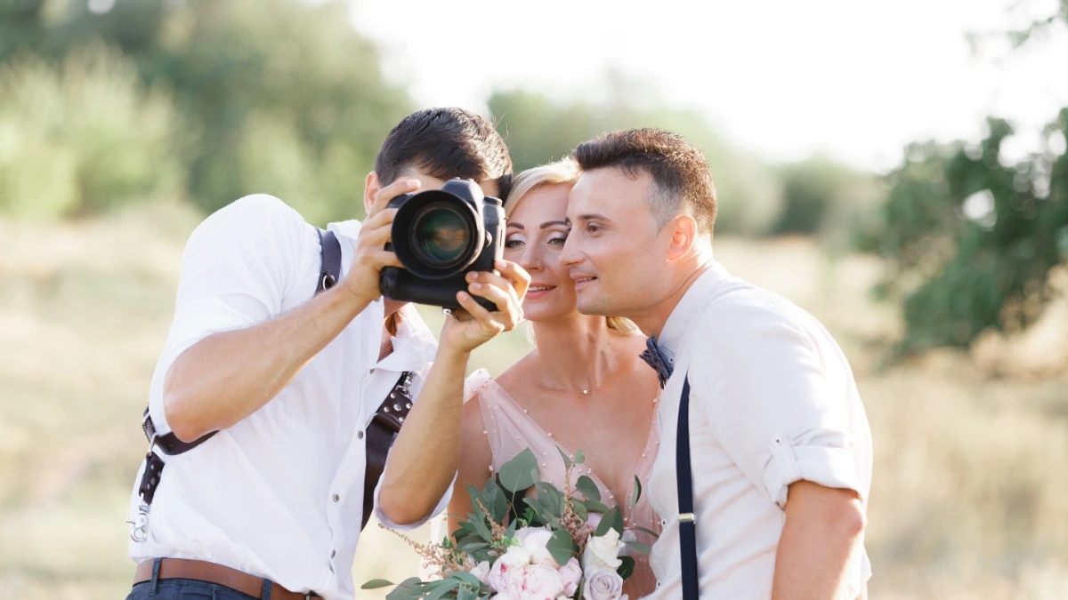 Photographer with bride and groom at their wedding