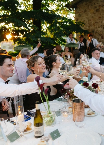 guest making a toast with a glass of white wine 